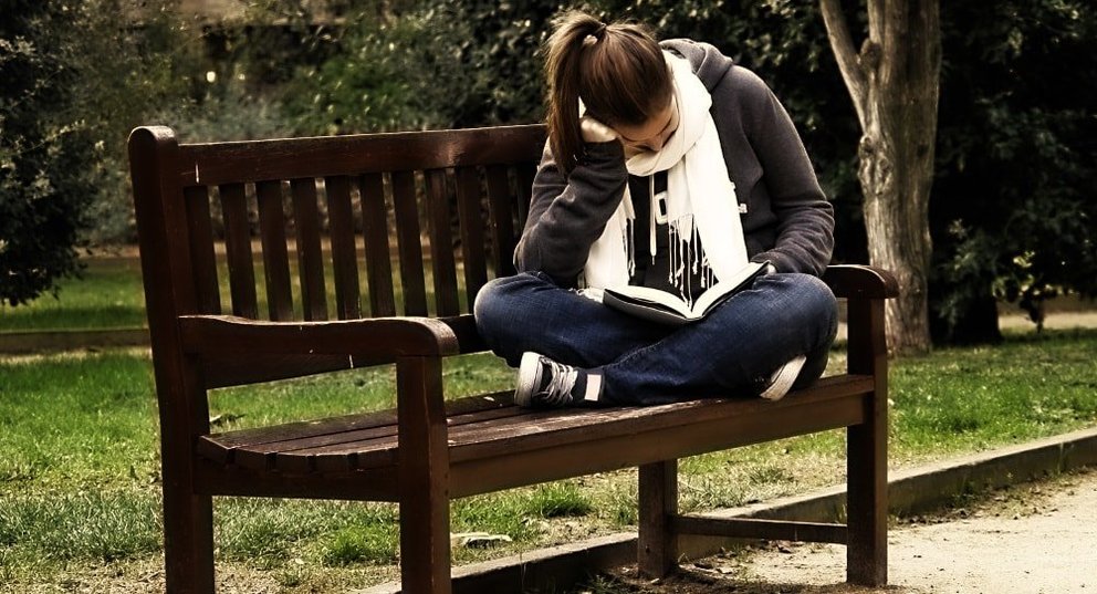 Rapaza lendo nun parque